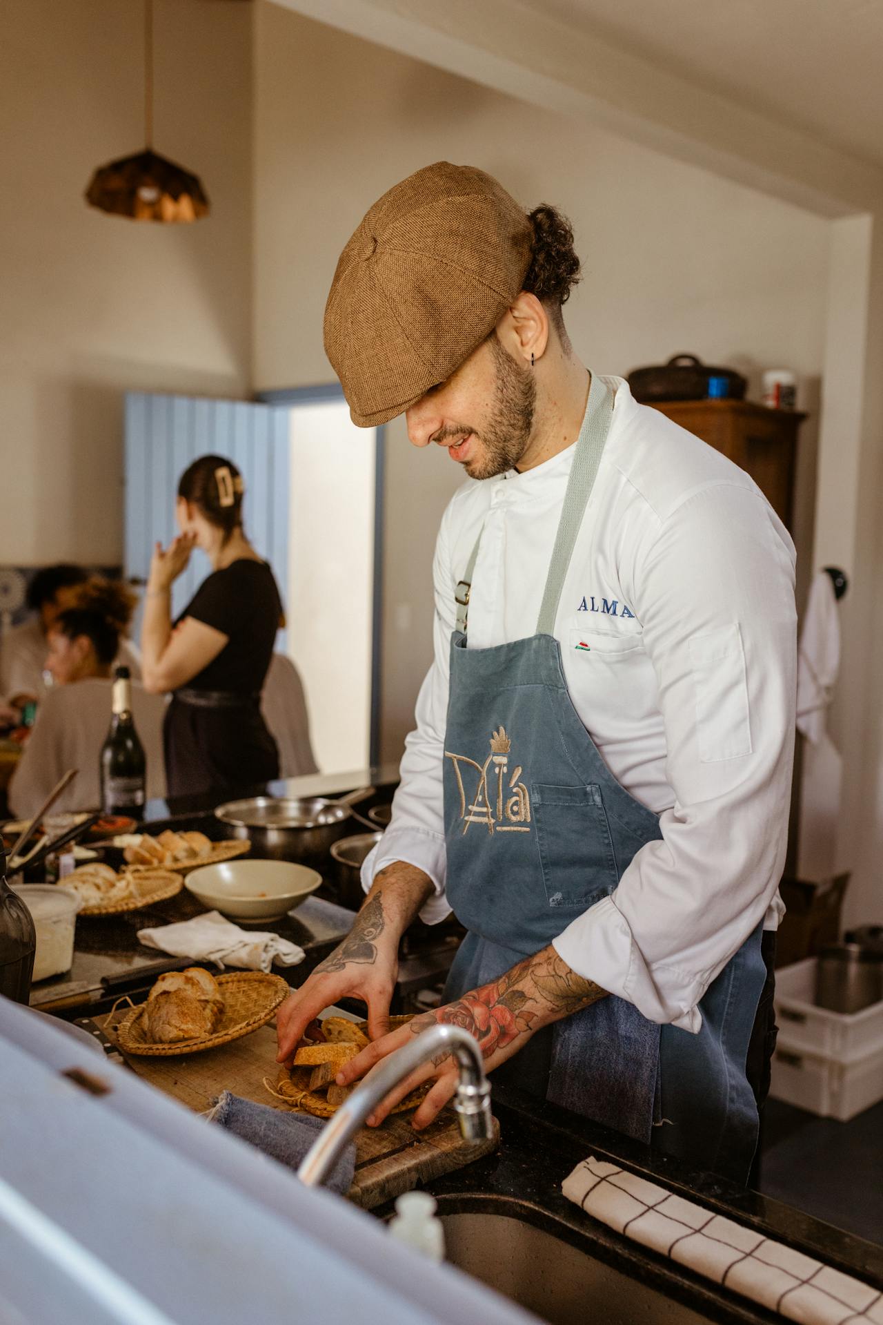 Chef Larry Cowling standing at his kitchen counter with a smile, a cast-iron skillet beside him.