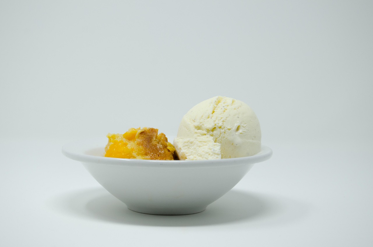 Peach cobbler with golden biscuit topping in a cast-iron dish.